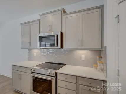 a kitchen with granite countertop white cabinets and white appliances