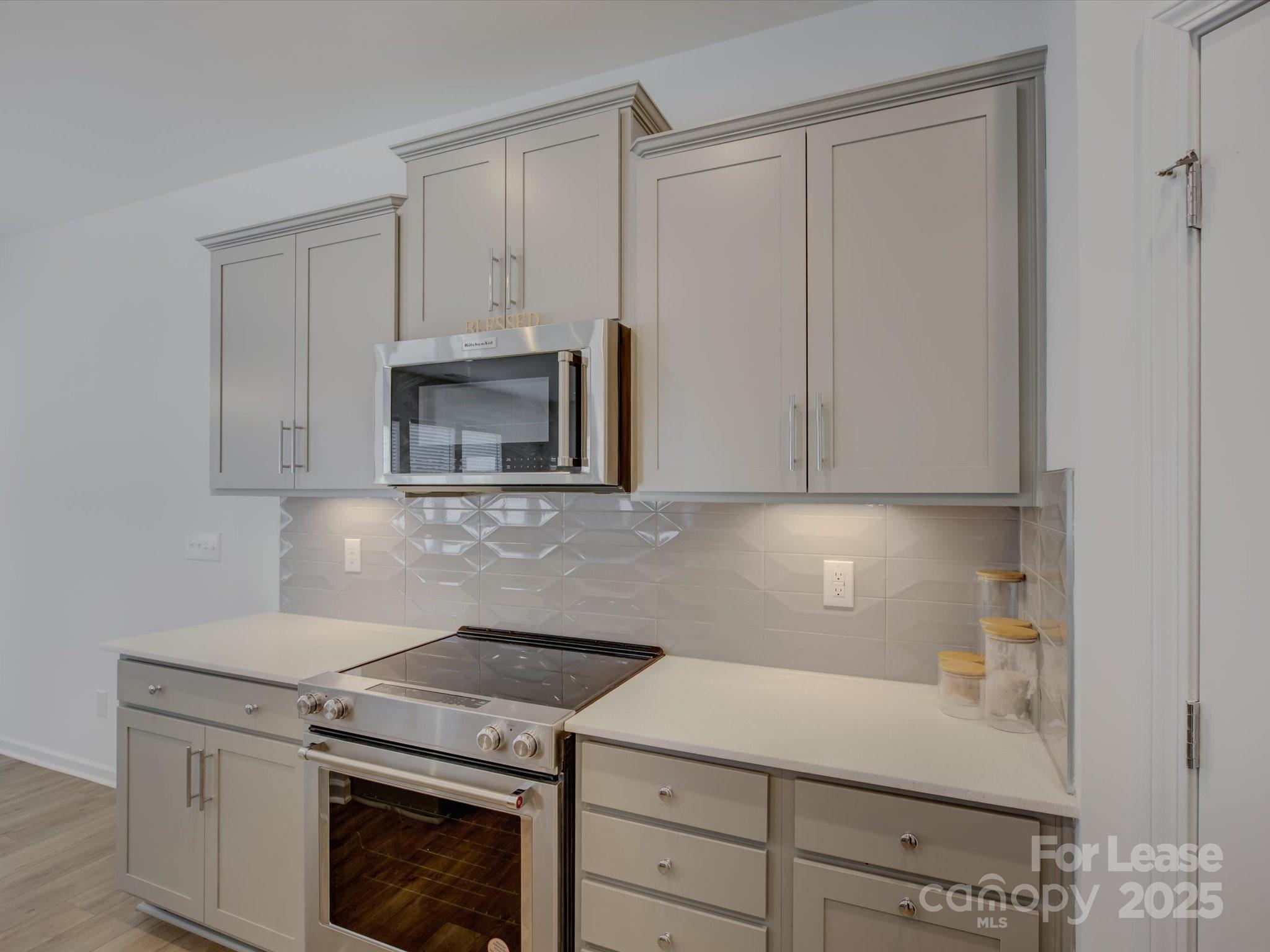 13124 Rover Street Charlotte, NC 28273 - Photo 12 of 46 a kitchen with granite countertop white cabinets and white appliances