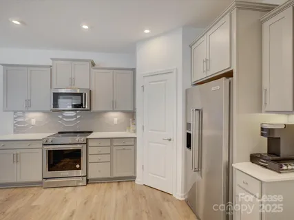 a kitchen with stainless steel appliances granite countertop a stove a refrigerator and a sink