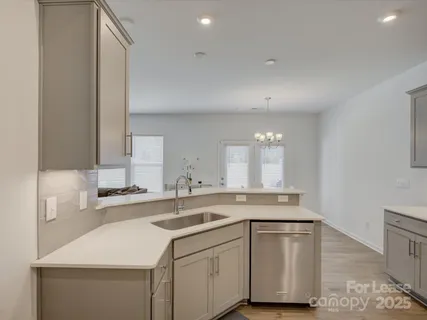 a kitchen with a sink cabinets and wooden floor