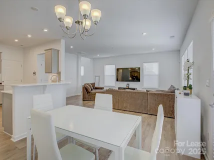 a living room with furniture a flat screen tv and kitchen view