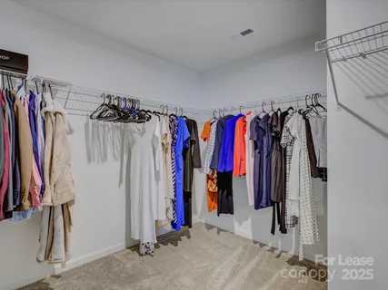 a view of walk in closet with clothes