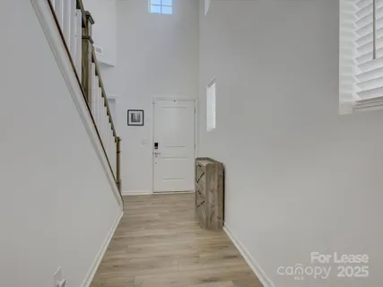 a view of a hallway with wooden floor and staircase