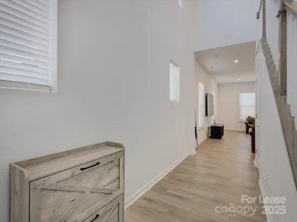 a view of a hallway with wooden floor and staircase
