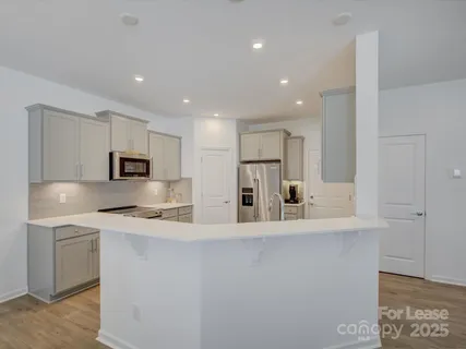 a kitchen with stainless steel appliances a refrigerator sink and microwave