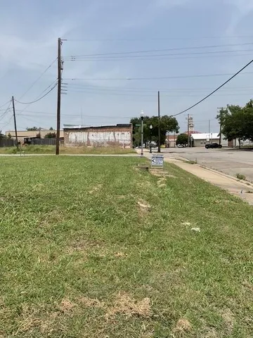 a view of a house with a yard and a car park