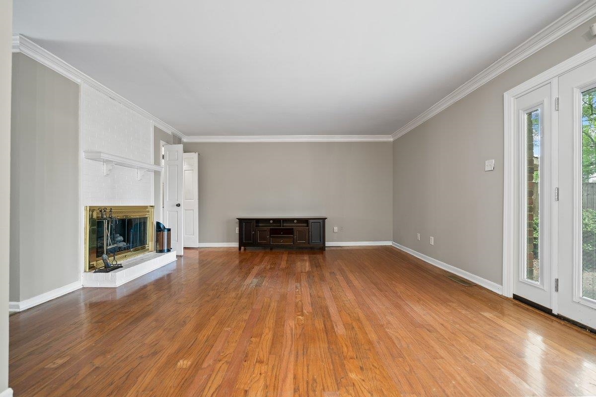 6942 Amberly Road, Unit 6942 Memphis, TN 38119 - Photo 13 of 23 an empty room with wooden floor fireplace and windows