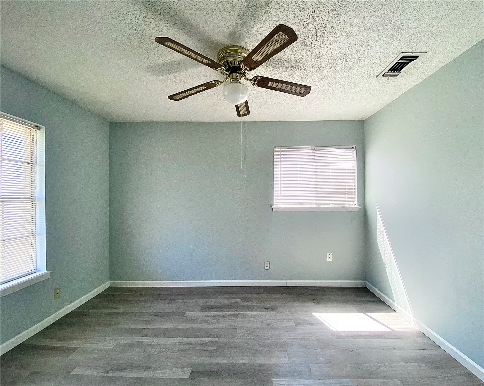 8602 Colonial Drive Austin, TX 78758 - Photo 12 of 19 an empty room with a ceiling fan and window