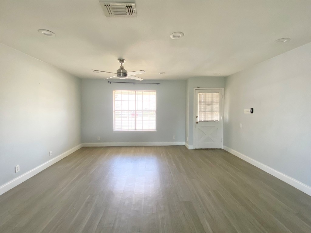 8602 Colonial Drive Austin, TX 78758 - Photo 6 of 19 an empty room with wooden floor and windows