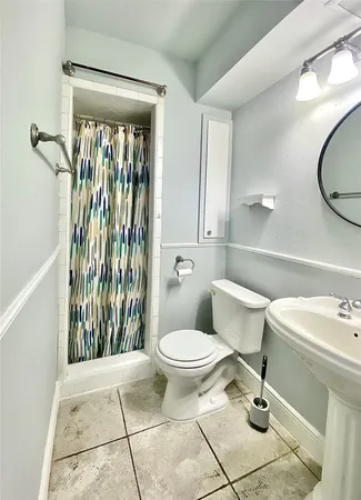 a bathroom with a toilet sink and mirror