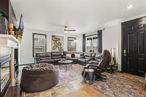 a living room with furniture hard wood floor and a fireplace