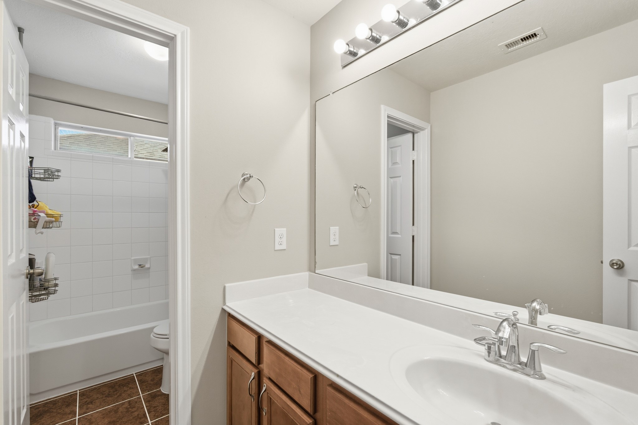 3214 Vinca Ranch Drive Katy, TX 77494 - Photo 19 of 26 Full upstairs bathroom featuring extended vanity, framed mirror, and shower/tub combo with tile surround.