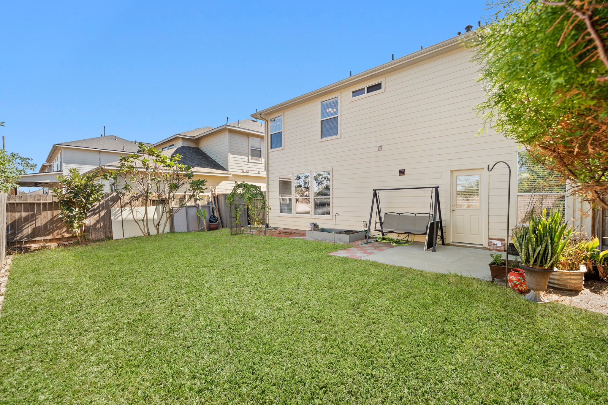 3214 Vinca Ranch Drive Katy, TX 77494 - Photo 22 of 26 Spacious fenced backyard with lush green grass, garden space, and mature trees. Perfect for outdoor entertaining, relaxing, or future landscaping projects.