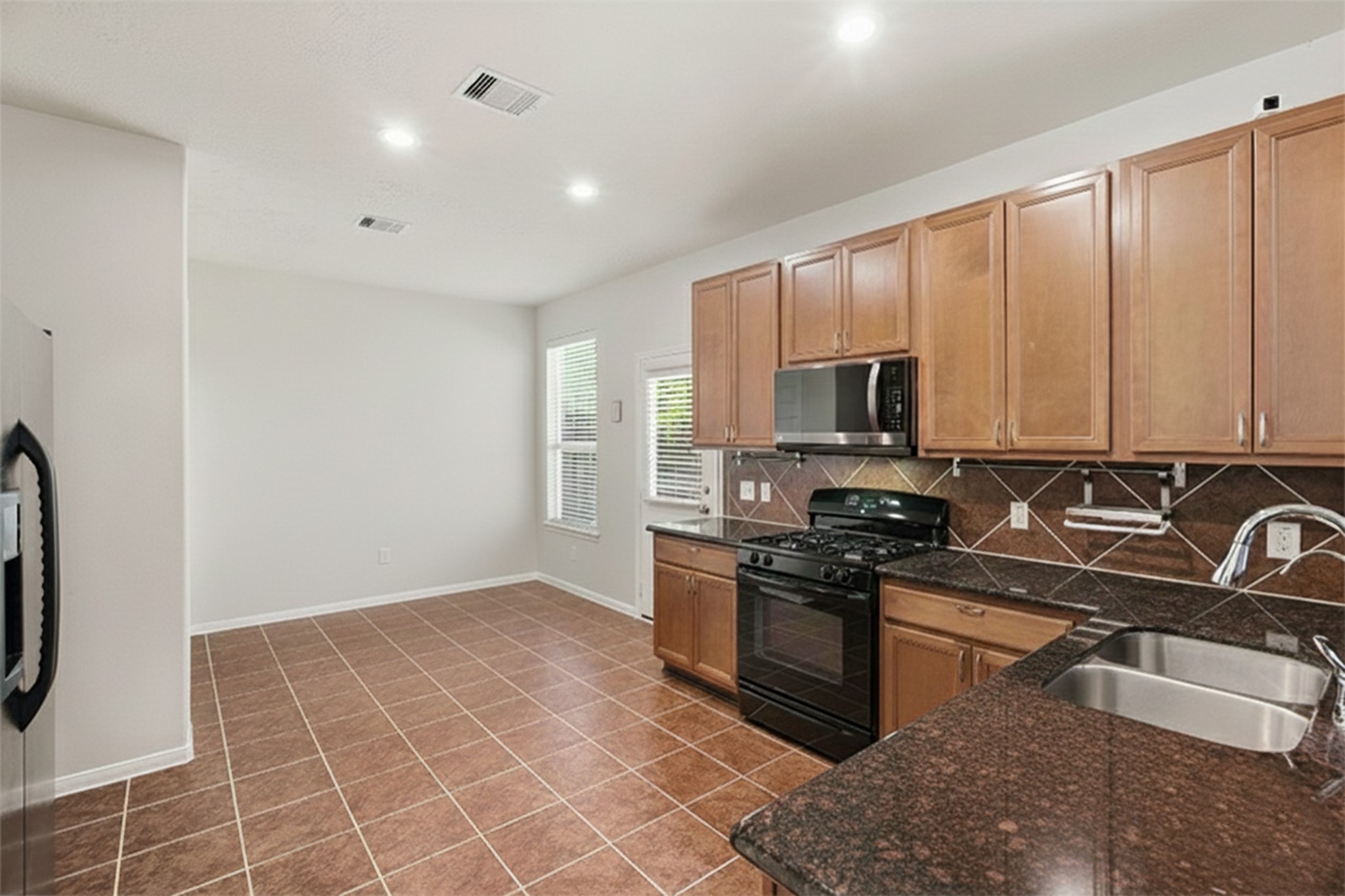 3214 Vinca Ranch Drive Katy, TX 77494 - Photo 8 of 26 a kitchen with stainless steel appliances granite countertop a stove a sink and a microwave
