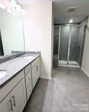 a spacious bathroom with a granite countertop sink and a mirror
