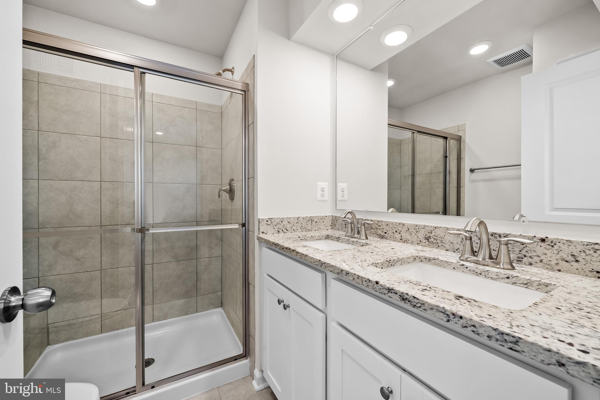 657 Mozart Way Baltimore, MD 21224 - Photo 11 of 39 a bathroom with a granite countertop sink a mirror and shower