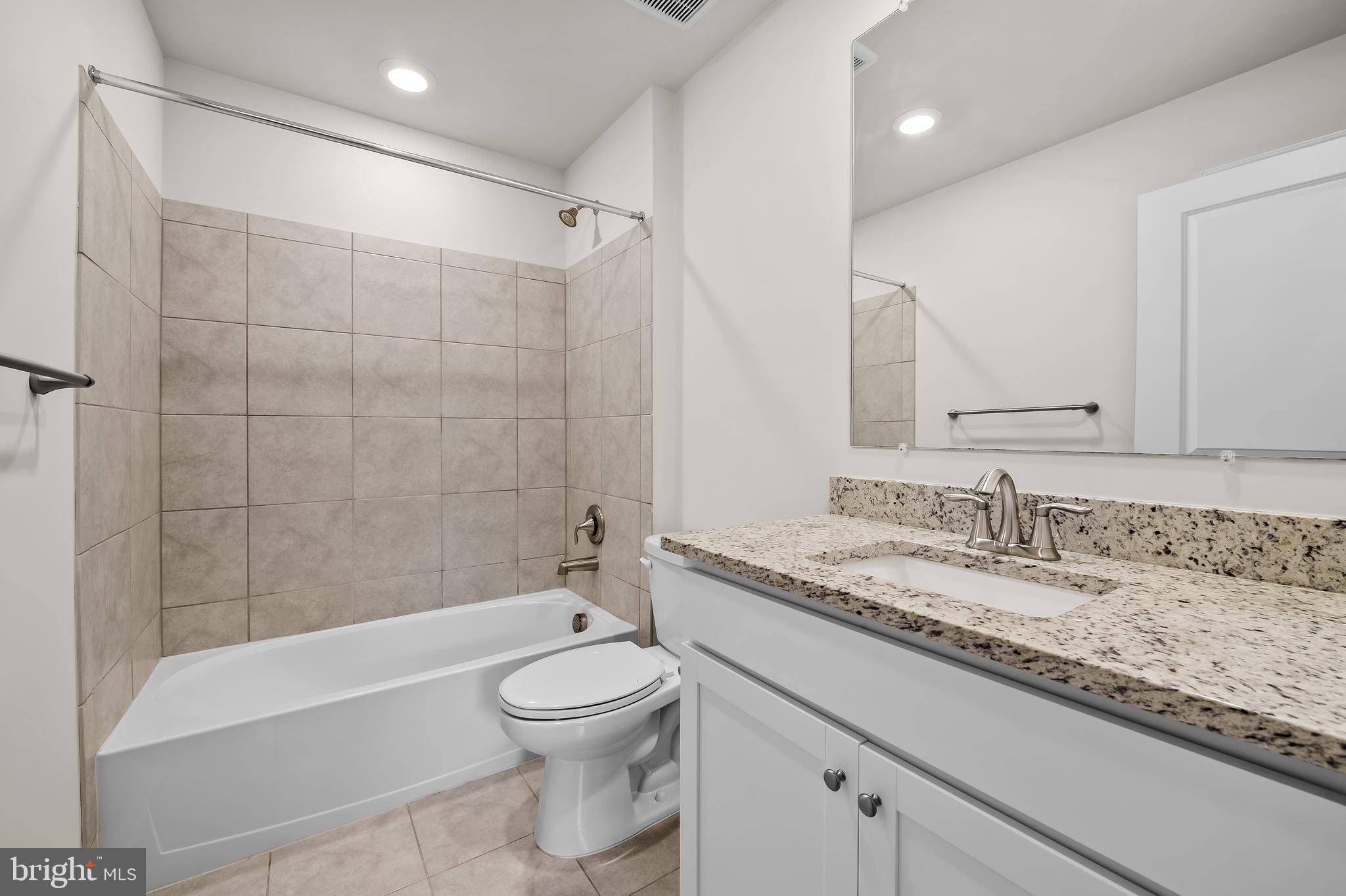 657 Mozart Way Baltimore, MD 21224 - Photo 14 of 39 a bathroom with a granite countertop sink a toilet and bathtub