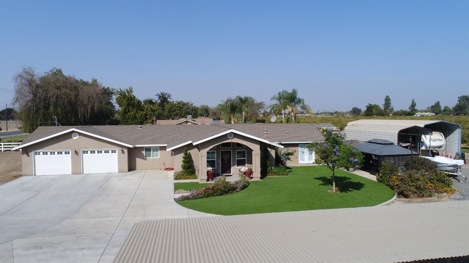 16760 West Hanford Armona Road Lemoore, CA 93245 - Photo 1 of 36 a aerial view of a house with a yard and garage