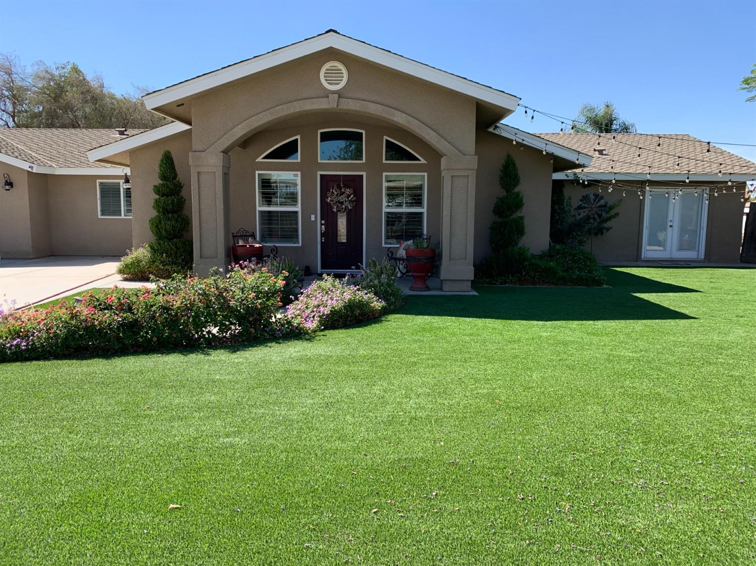 16760 West Hanford Armona Road Lemoore, CA 93245 - Photo 6 of 36 a front view of a house with a garden