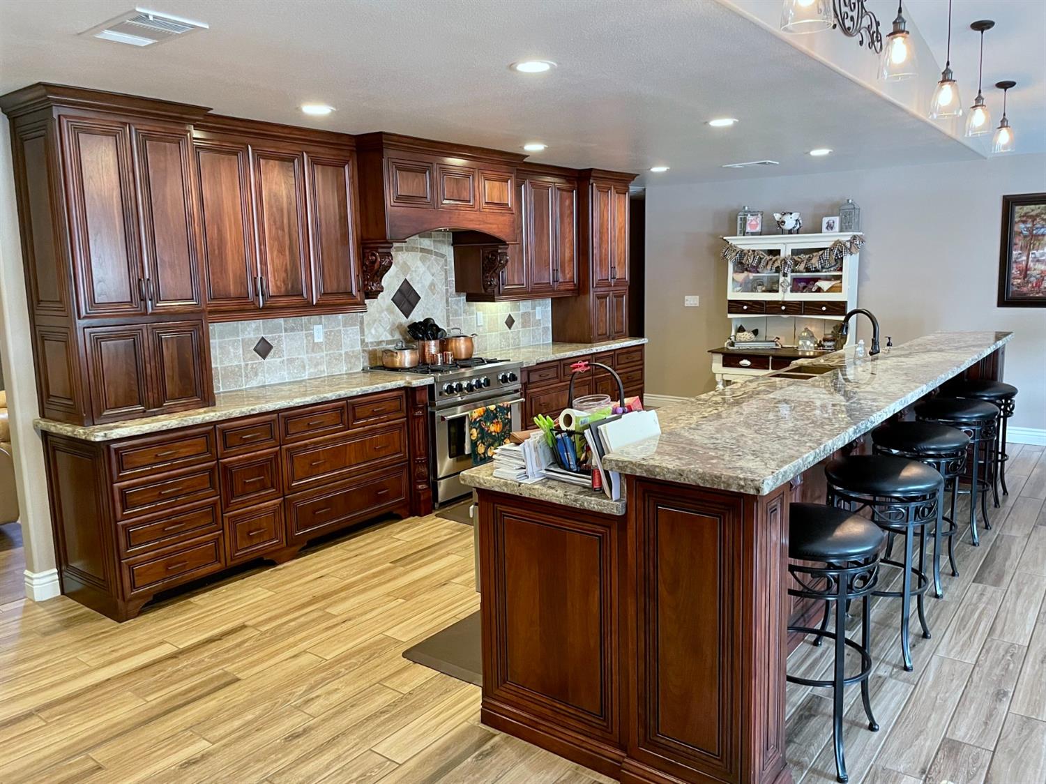 16760 West Hanford Armona Road Lemoore, CA 93245 - Photo 9 of 36 a kitchen with kitchen island granite countertop wooden cabinets and a refrigerator