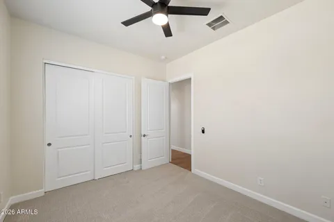 an empty room with a window and a fan