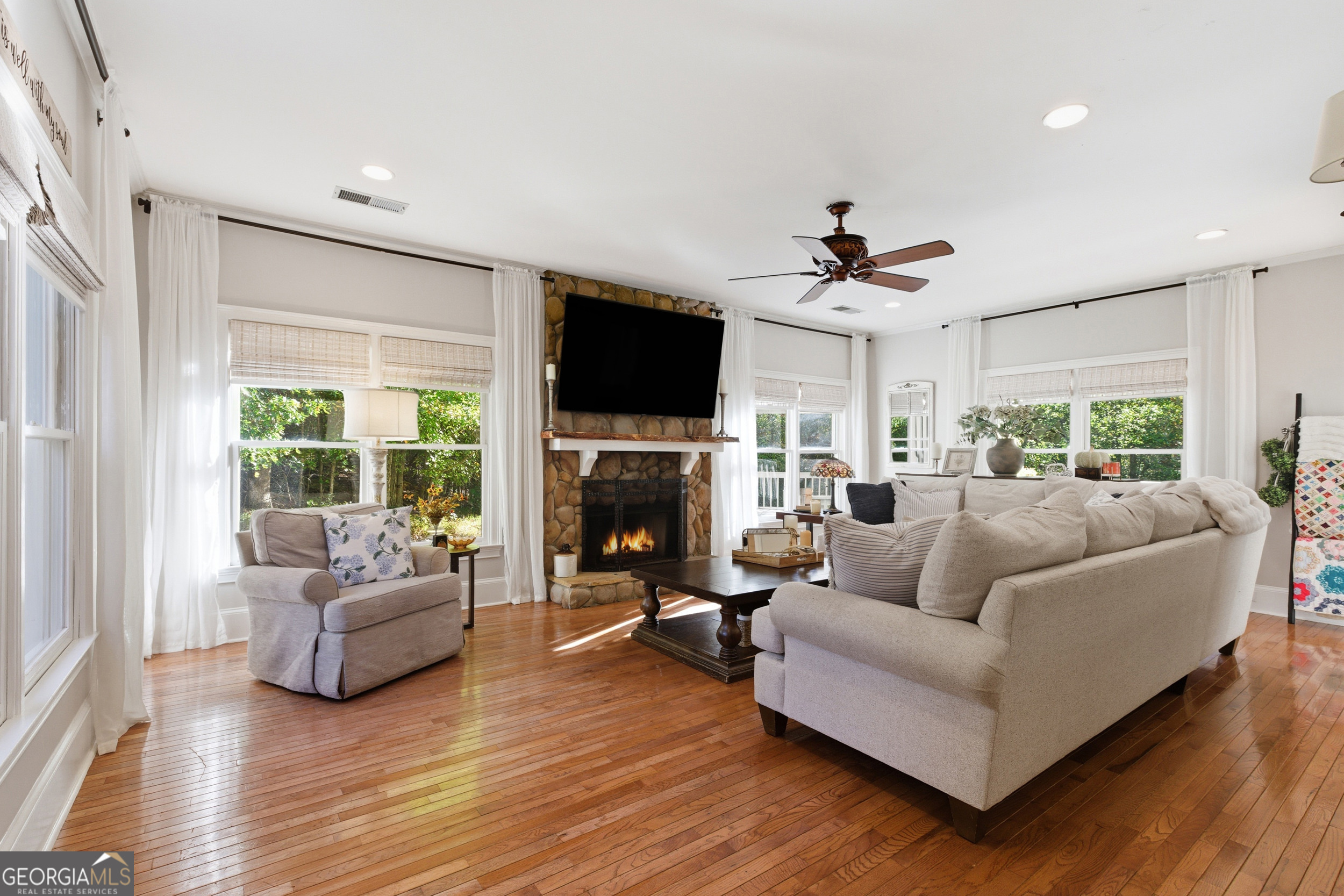 478 Chattahoochee Glen Road Clarkesville, GA 30523 - Photo 16 of 58 a living room with furniture a fireplace and a flat screen tv