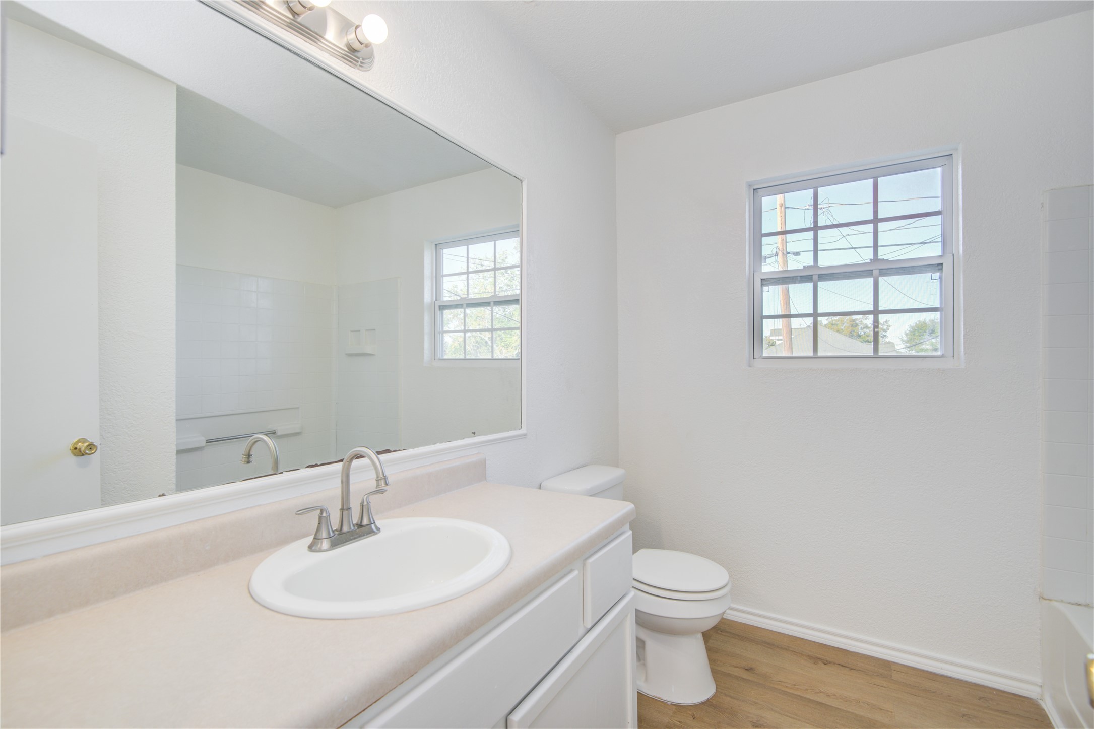 424 South Avenue B Freeport, TX 77541 - Photo 21 of 33 a bathroom with a toilet a sink a mirror and a window