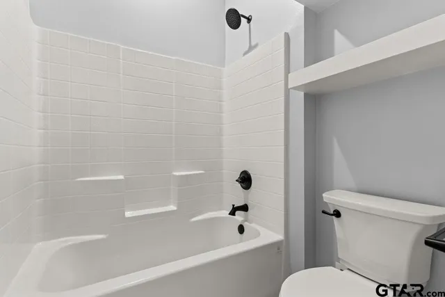 an empty room with chandelier fan and windows