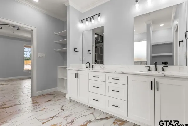 a spacious bathroom with a double vanity sink a mirror and a bathtub