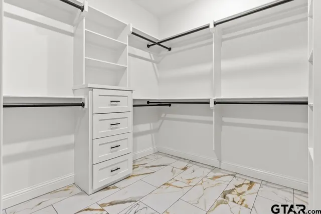 a view of walk in closet with empty racks