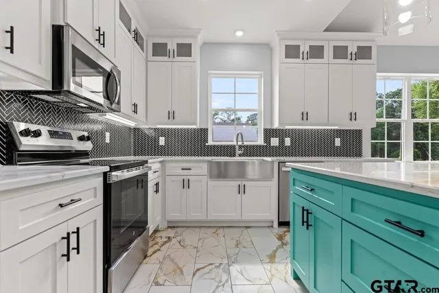 a kitchen with granite countertop a sink a stove and cabinets