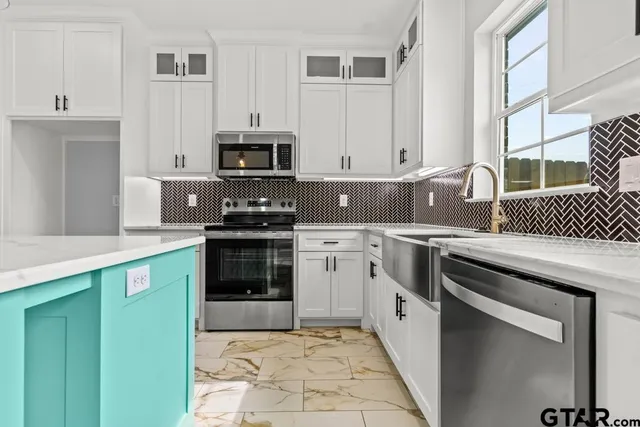 a kitchen with stainless steel appliances granite countertop a stove a sink and a microwave