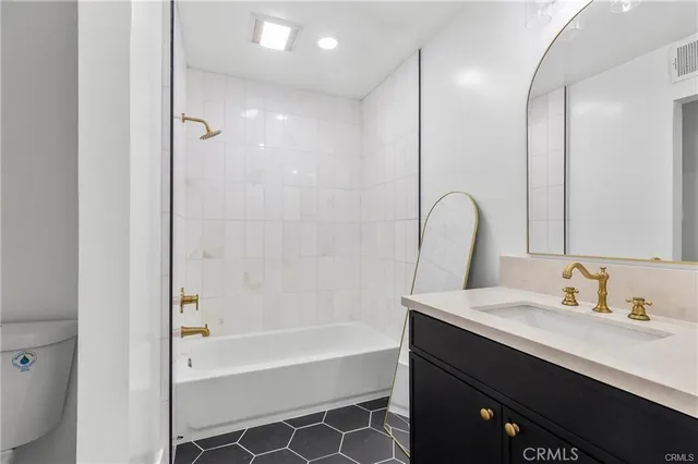 a bathroom with a bathtub sink vanity and mirror