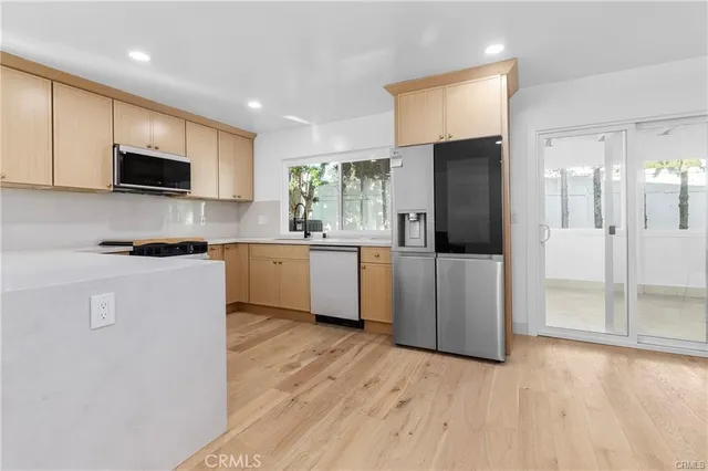 a kitchen with stainless steel appliances granite countertop a refrigerator a sink a stove and cabinets