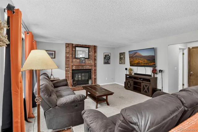 a living room with furniture a flat screen tv and a fireplace