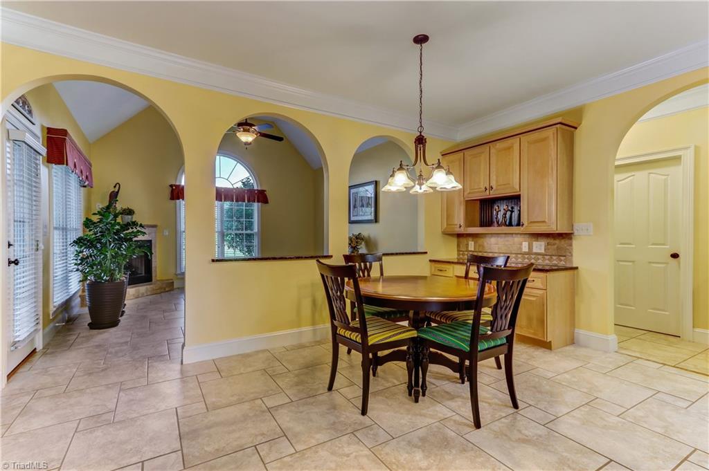5403 Red Fox Drive Oak Ridge, NC 27310 - Photo 7 of 30 The Breakfast Room has easy care tile flooring, Crown molding, chandelier, and built-in cabinets with granite counter top.