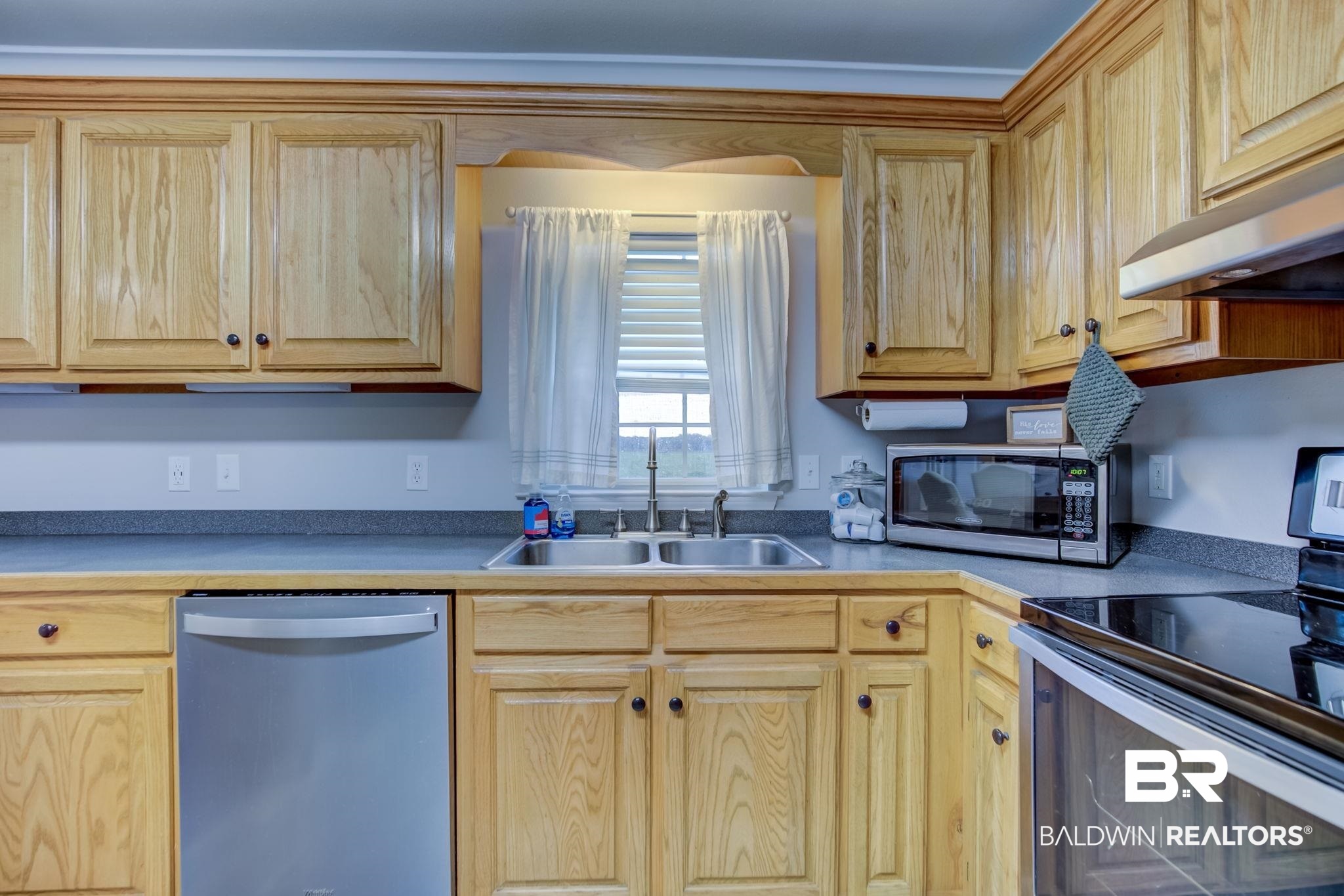 18732 Fairground Road Robertsdale, AL 36567 - Photo 14 of 46 Kitchen with stainless steel appliances, light brown cabinets, sink, and wall chimney range hood