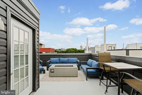 a view of roof deck with couches and potted plants