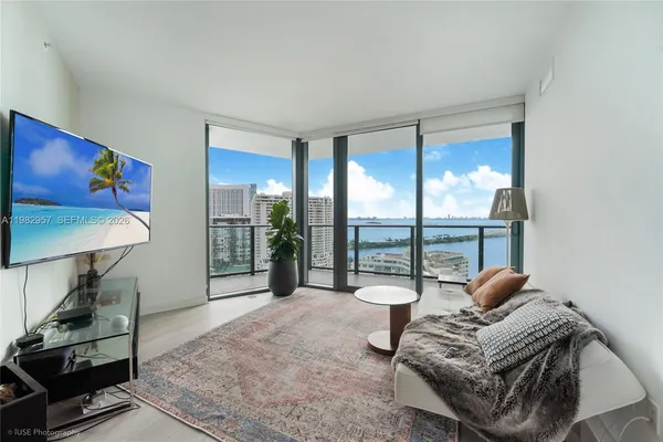 a living room with furniture and a floor to ceiling window