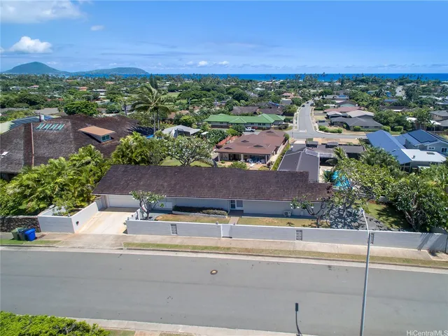 an aerial view of a city with lots of residential buildings ocean and mountain view in back
