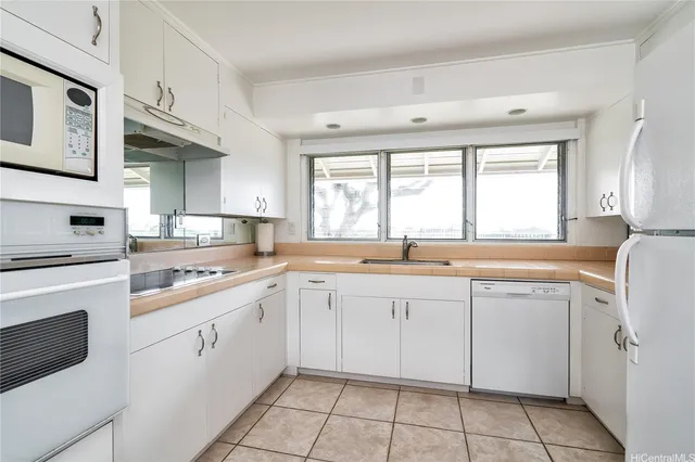 a kitchen with cabinets appliances and a window