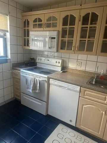 a kitchen with stainless steel appliances granite countertop a sink and a refrigerator