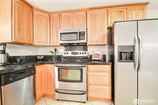 a kitchen with stainless steel appliances granite countertop a refrigerator stove and sink
