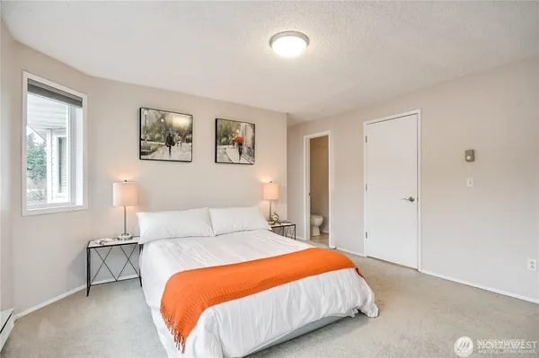 a bedroom with a bed and painting on the wall