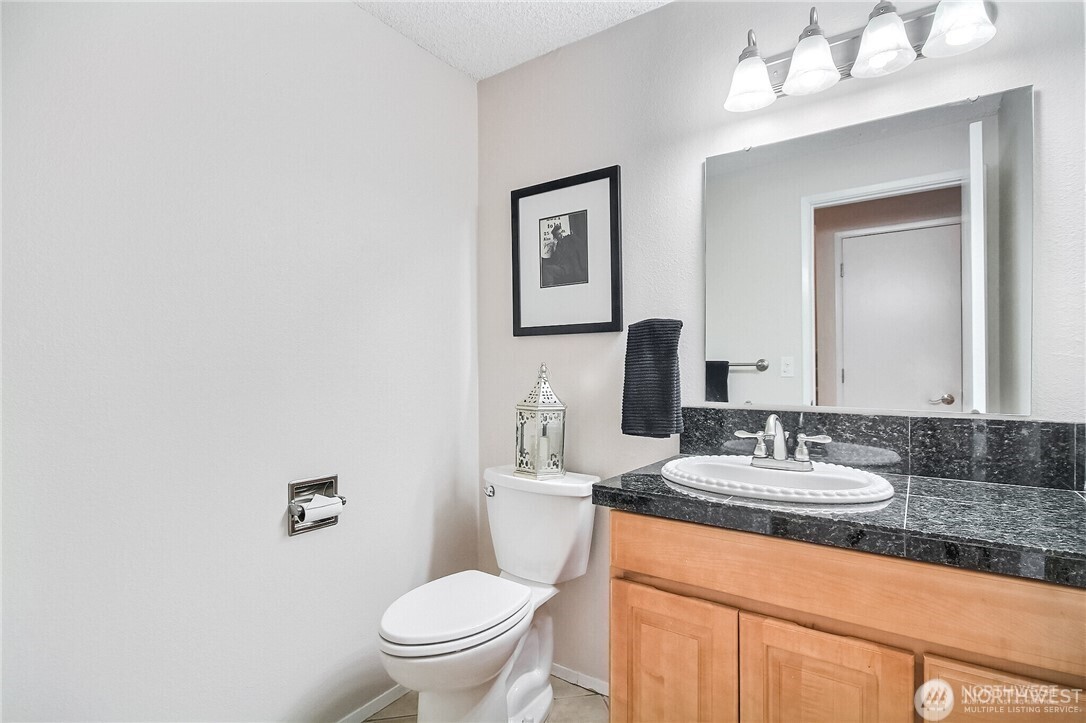 4514 Southwest 319th Place, Unit D Federal Way, WA 98023 - Photo 8 of 21 a bathroom with a granite countertop sink mirror vanity and toilet