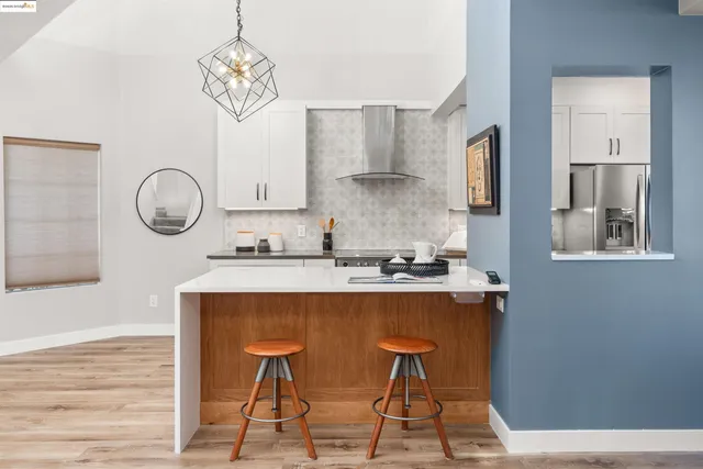 a kitchen with stainless steel appliances granite countertop a table chairs sink and cabinets