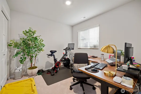 a view of a workspace with furniture and a window