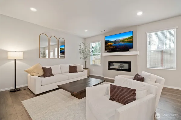 a living room with furniture a flat screen tv and a fireplace