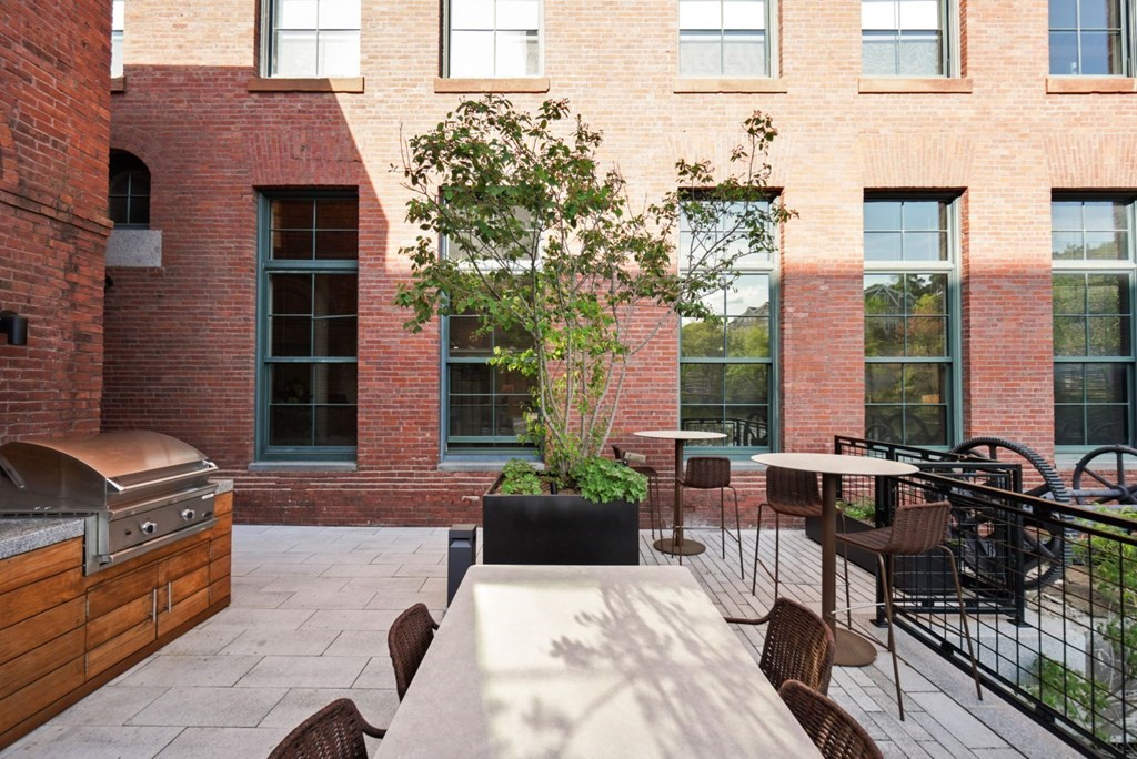 1245 Adams Street, Unit B210 Boston, MA 02124 - Photo 20 of 23 a view of a patio with couches table and chairs and potted plants