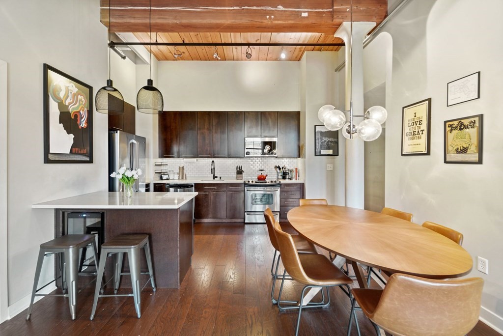 1245 Adams Street, Unit B210 Boston, MA 02124 - Photo 5 of 23 a kitchen with a table chairs refrigerator and cabinets